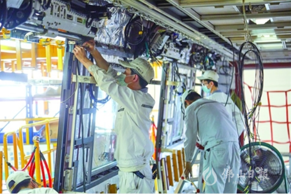 佛山中车组装车间内，工作人员在列车内作业。该企业的生产车间目前已100%恢复产能。（资料图片）/佛山日报记者吕润致摄